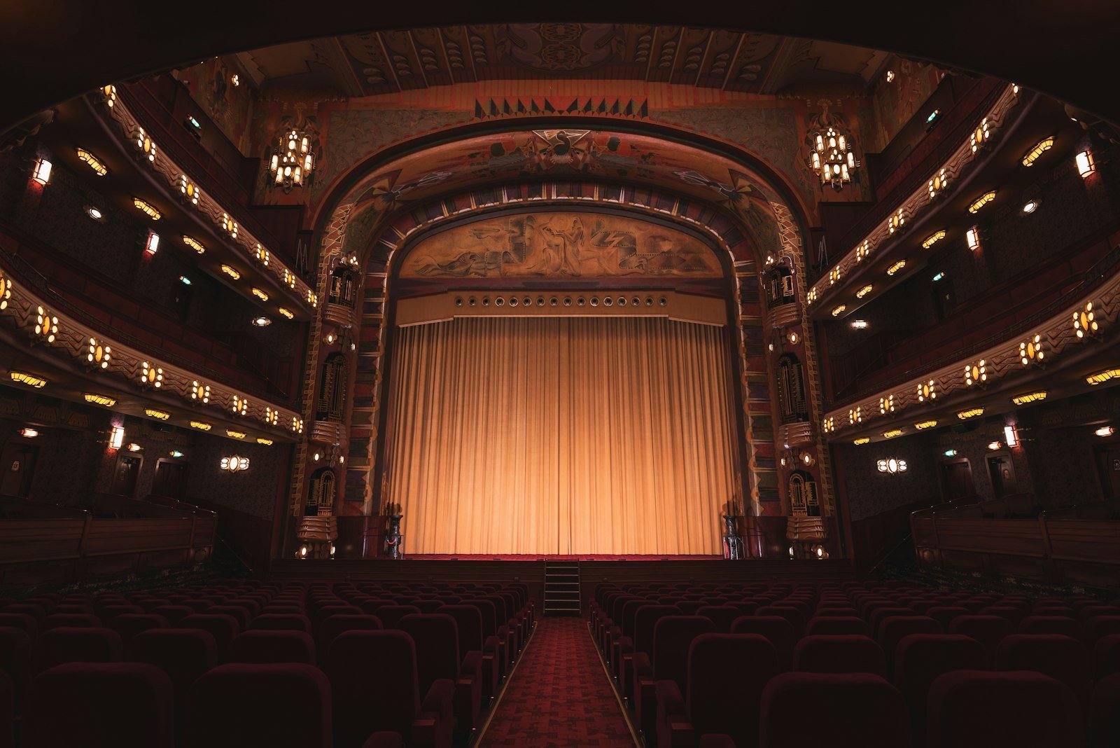 Teatro vacío con butacas rojas y cortina dorada
